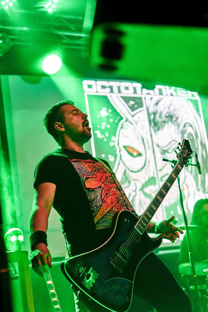 Rafał, gitarzysta zespołu Octotanker, podczas doom metalowego koncertu wśród zielonych świateł i scenicznego dymu.